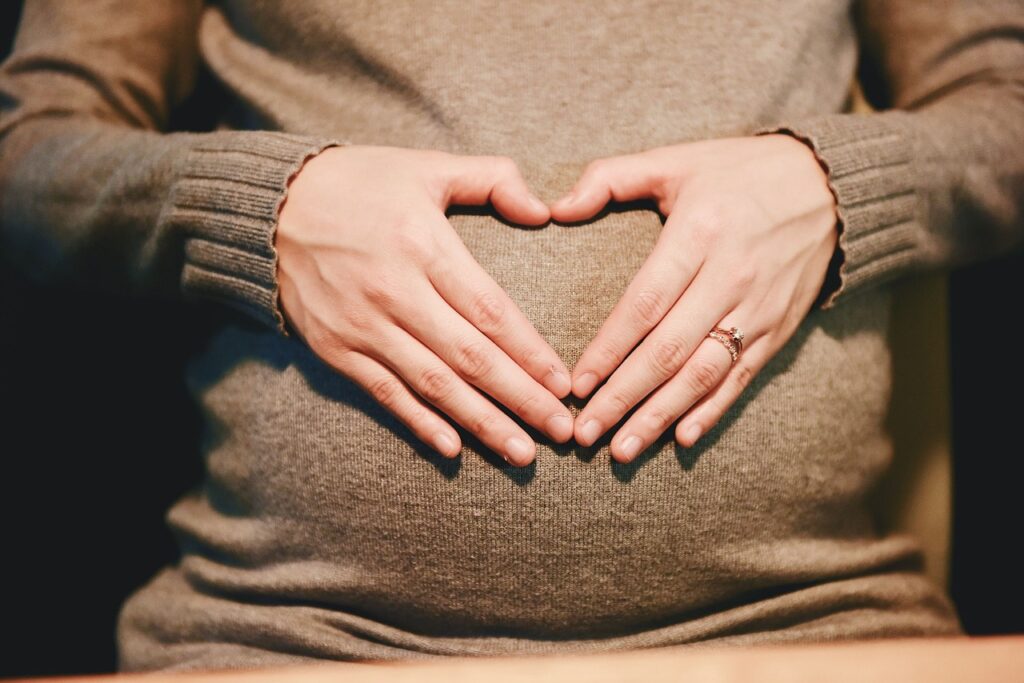 お腹に手を添える妊娠中の女性の姿