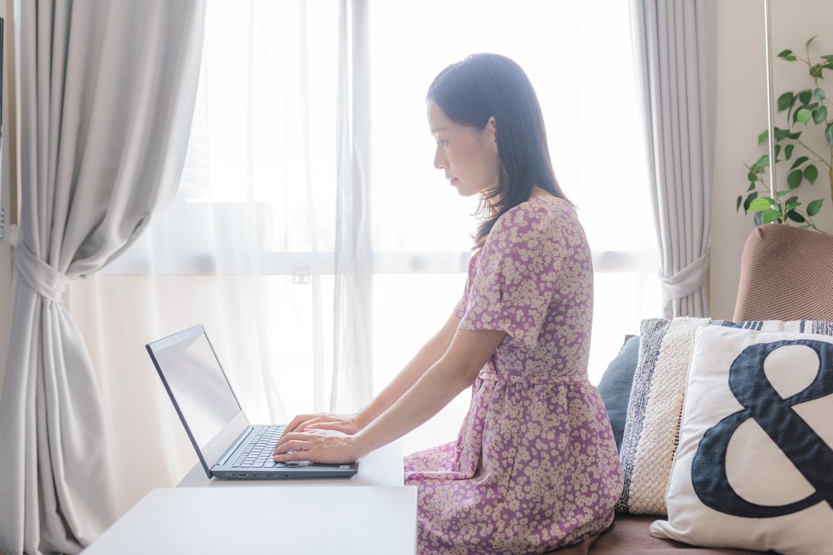 明るい部屋でノートパソコンに向かう女性