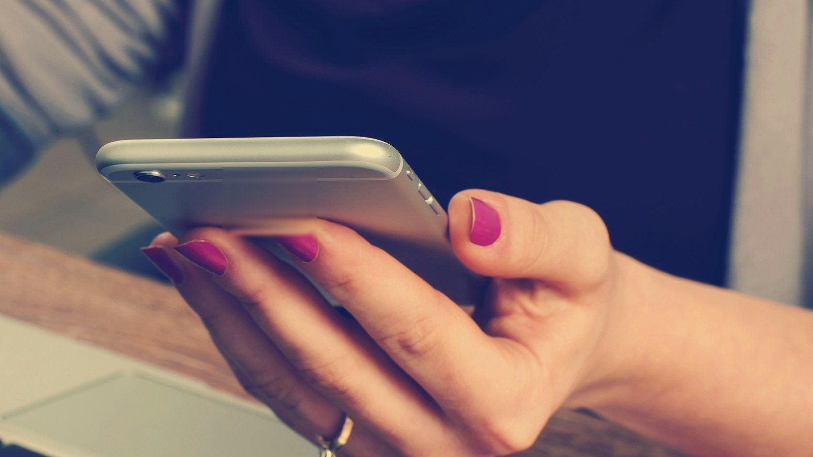 スマートフォンで学童の募集案内を調べる女性の手元