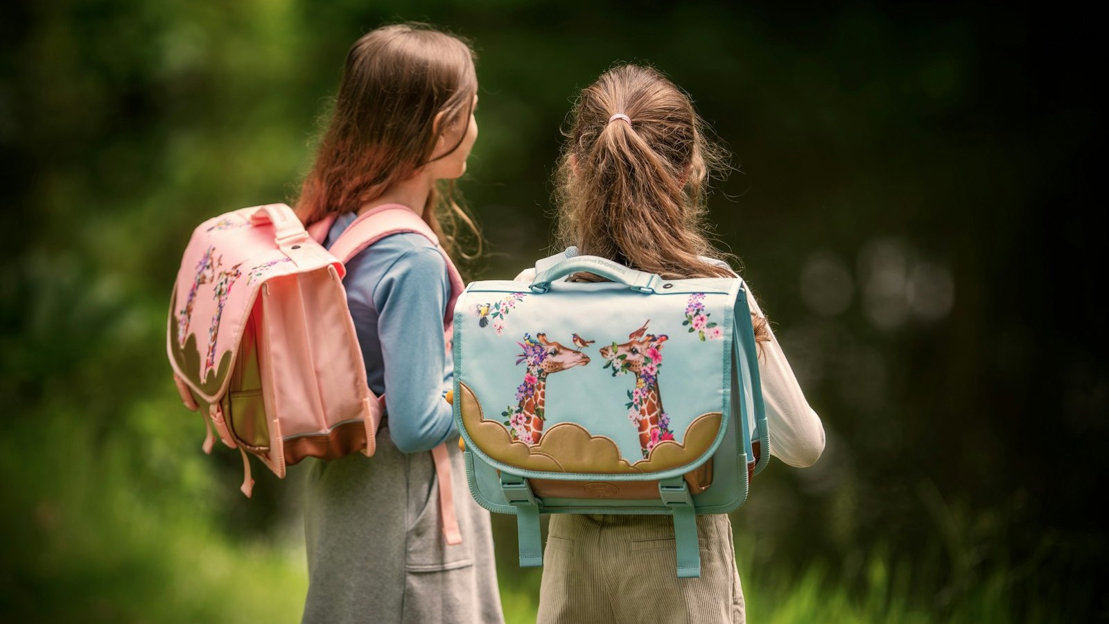 かばんを背負って歩く子ども2人の後ろ姿