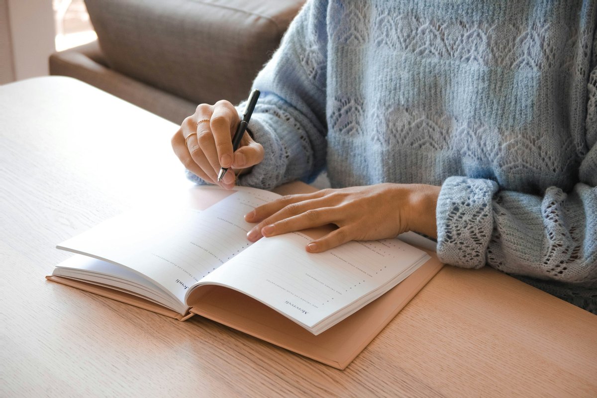 ノートに書き込む女性の手元