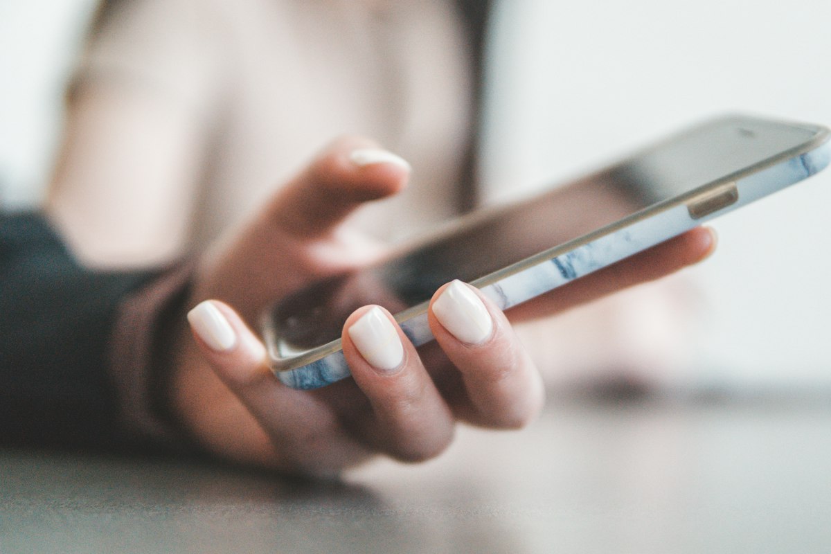 スマートフォンを操作する女性の手元
