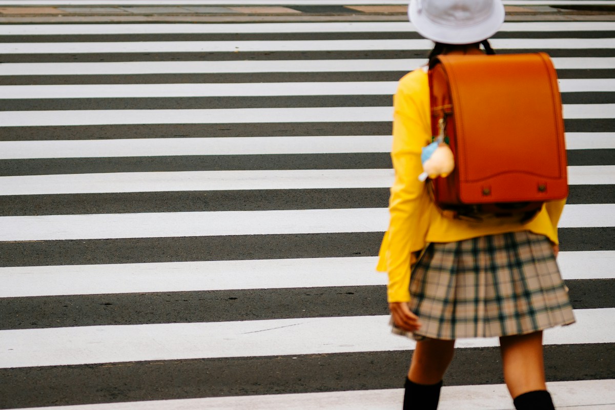 ランドセルを背負って横断歩道を渡る小学生